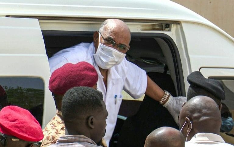 Sudans ousted president Omar al Bashir gets out of a car to attend his trial at a Khartoum court in this AFPTV image AFP Photo Mohammed ABUAMRAIN 768x485 1