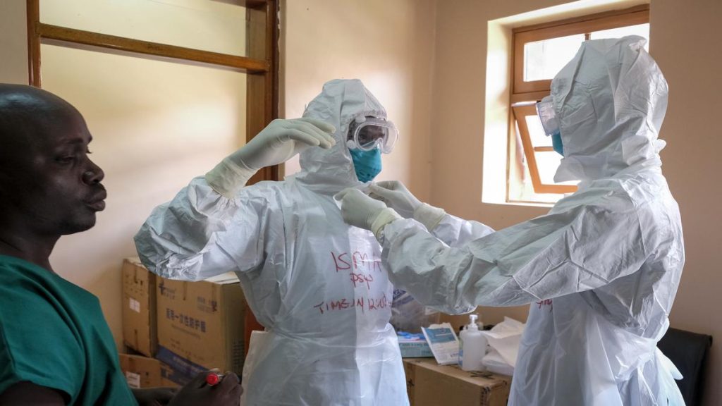 Doctors put on protective equipment as they prepare to visit a patient in Uganda